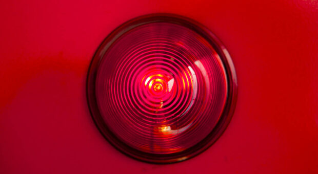 Das Bild einer roten Warnlampe auf rotem Hintergrund.