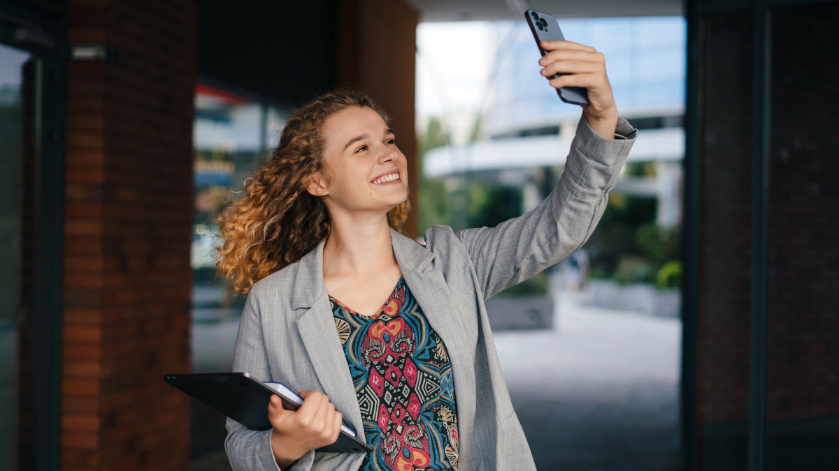 Frau macht Selfie und lächelt dabei